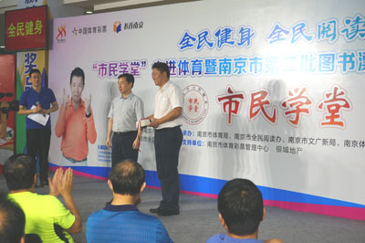 1470900889895534.jpg 市体彩中心副主任上台接收图书捐赠.jpg